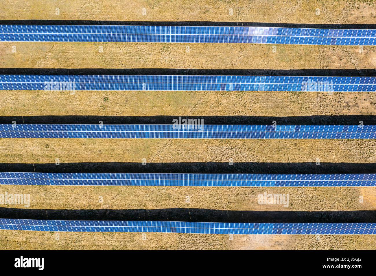 Solar farm aerial view, rows of PV panels by a small house Stock Photo