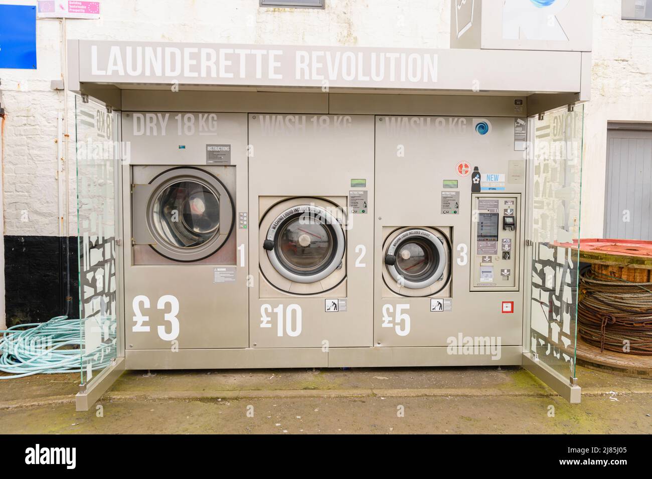 Automated launderette with a tumble drier, large washing machine and small washing machine Stock Photo