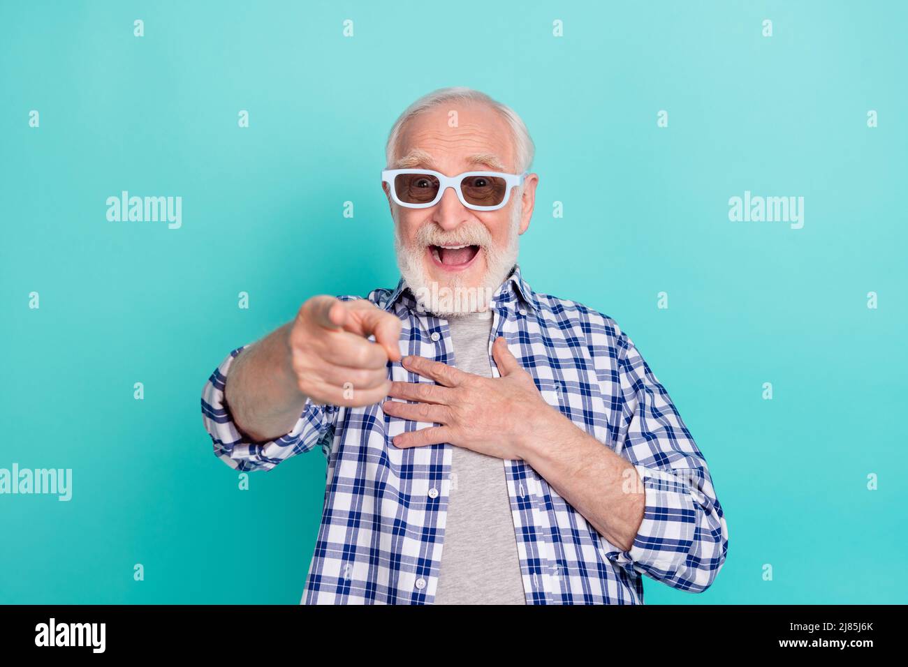 Photo of cheerful overjoyed ecstatic grandfather laughing watching comedy film isolated on teal color background Stock Photo