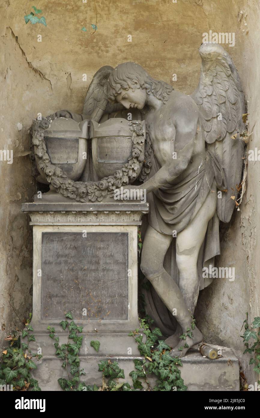 Mourning angel depicted on one of the abandoned funeral monuments at Olšany Cemetery in Prague, Czech Republic. Stock Photo