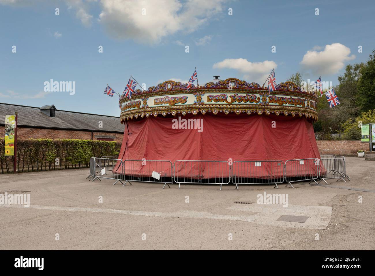 a fairground carousel covered up for winter. with a blue sky and clouds Stock Photo