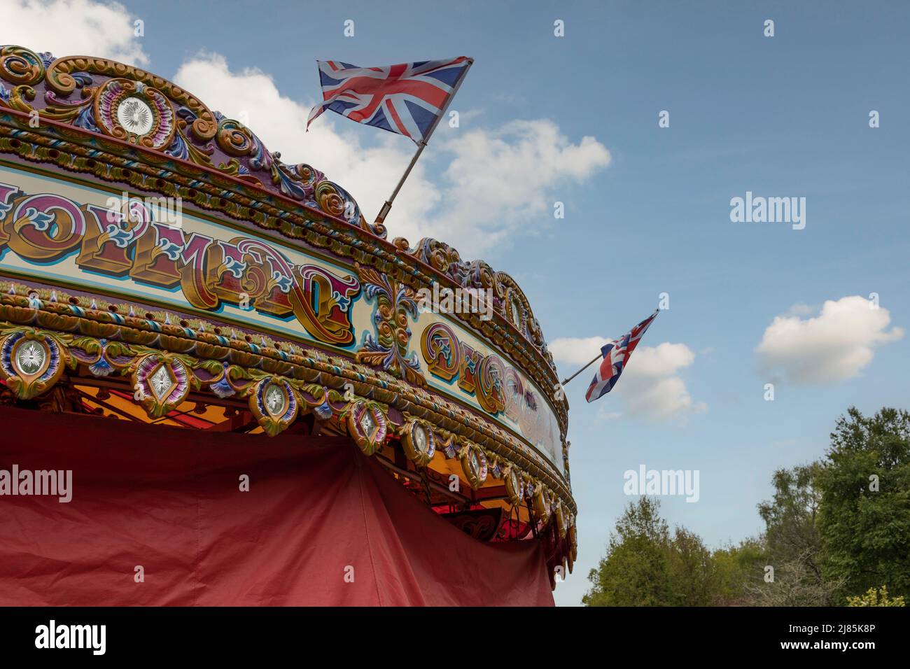 a fairground carousel covered up for winter. with a blue sky and clouds Stock Photo