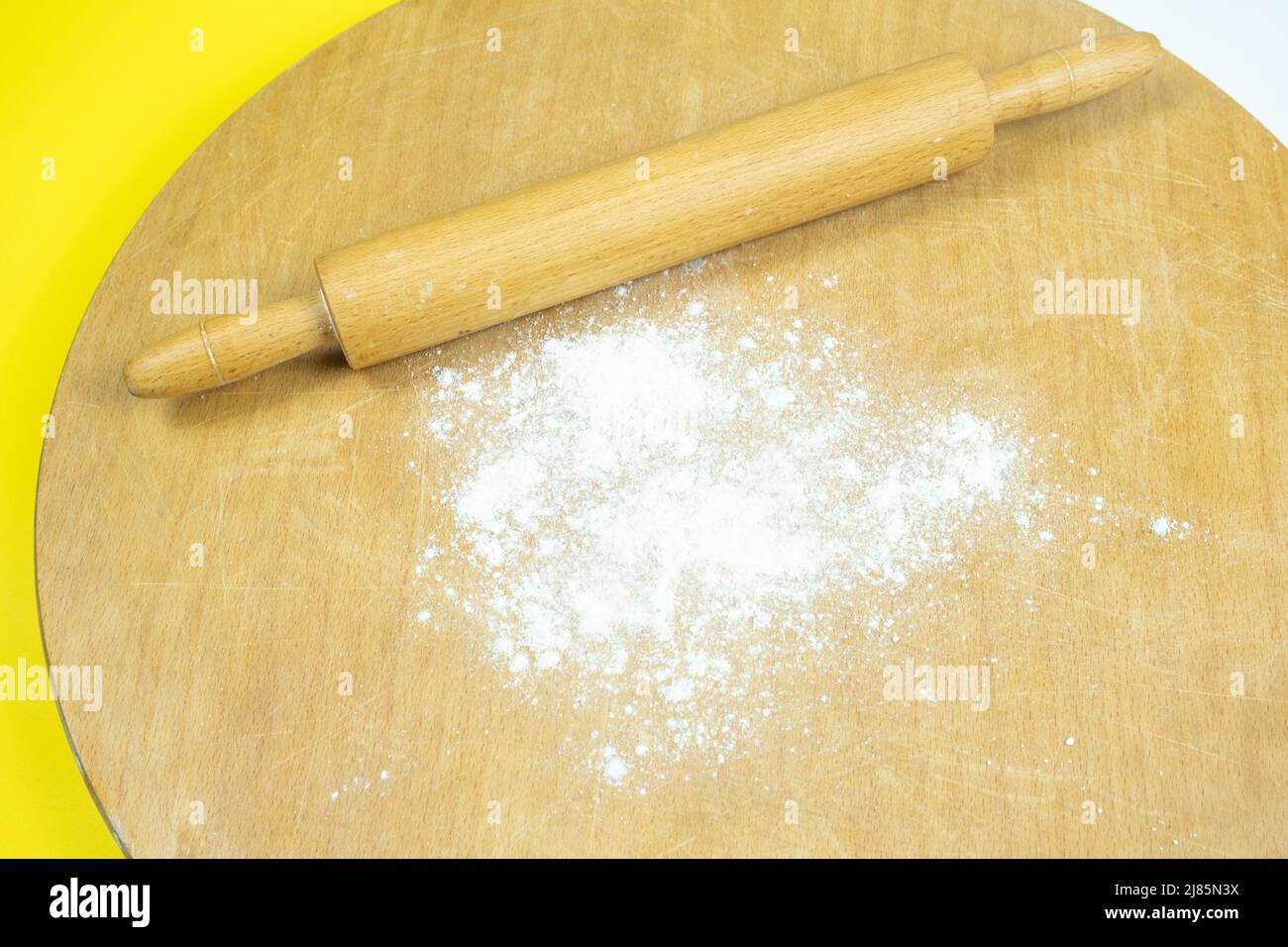 Rolling pin on traditional circle wooden board, top view of roller and some flour, cooking concept, making homemade bread Stock Photo
