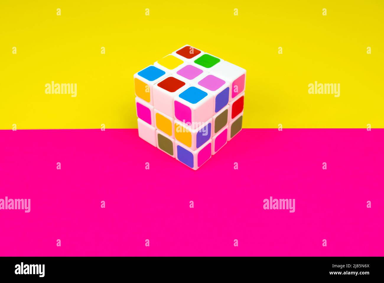Colorful cube with pink and yellow background, intelligence and brain game, top view, top view of cube Stock Photo