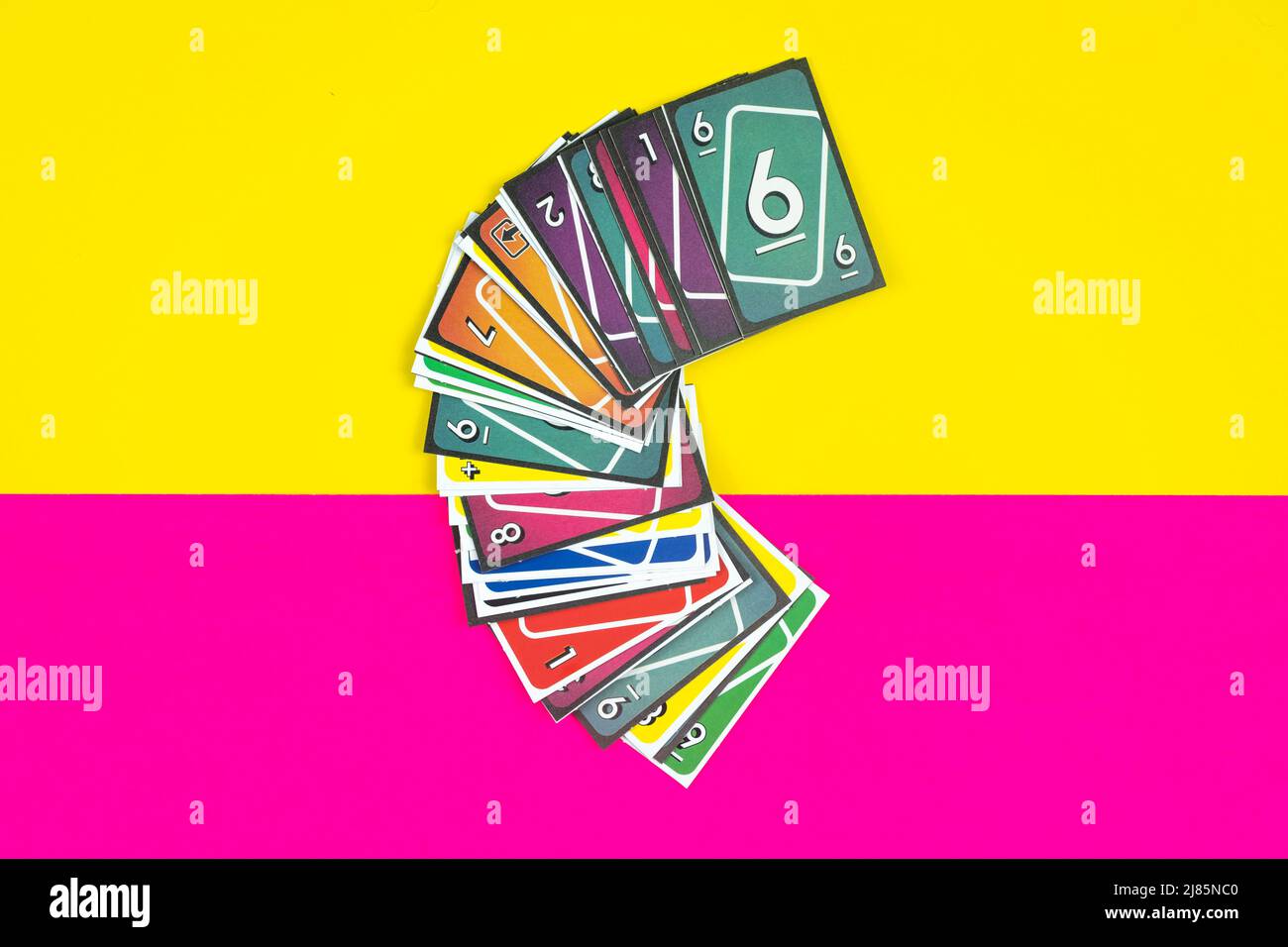 Playing cards, colorful playing card deck, entertainment and fun concept, yellow and pink background, hanging out with friends idea, top view Stock Photo
