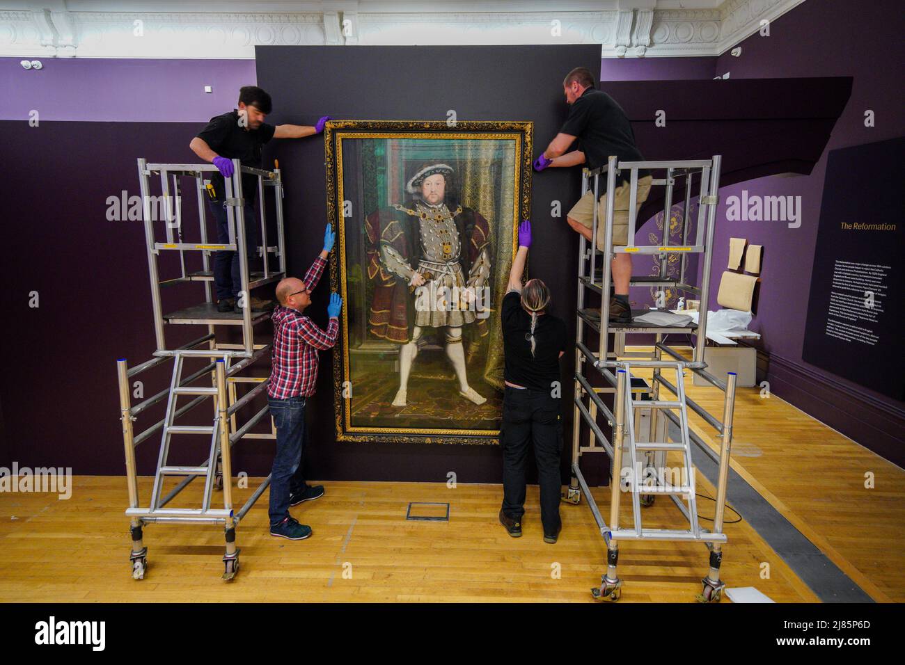 Gallery staff erect a painting of Henry the VIII during a preview of