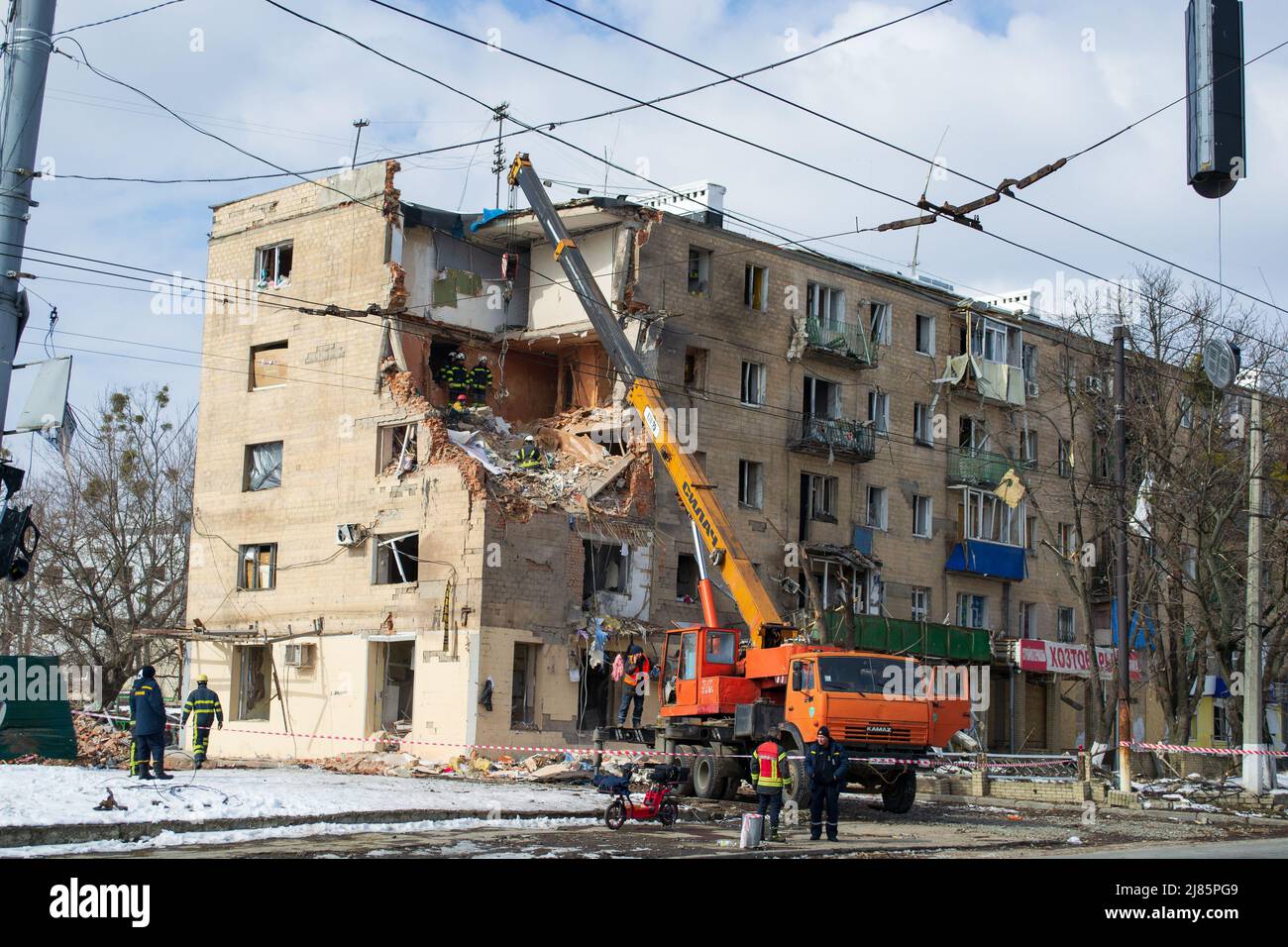 Kharkiv, Ukraine - 05.06.2022: Terrible destroyed building in city street crane dismantling damage house destruction broken due to bombing russian agg Stock Photo