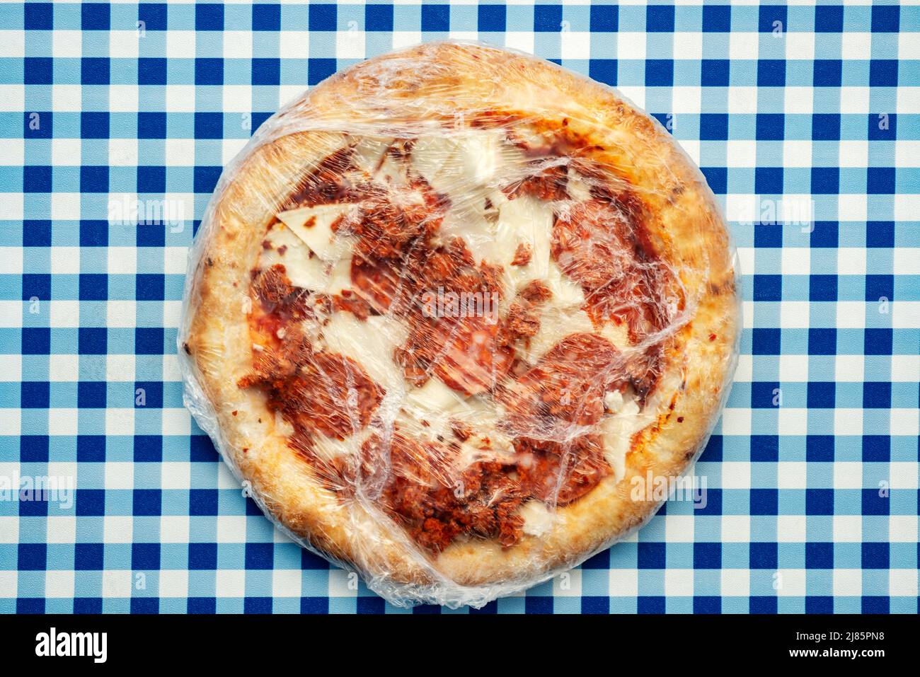 Spicy pepperoni pizza in plastic wrapper Stock Photo