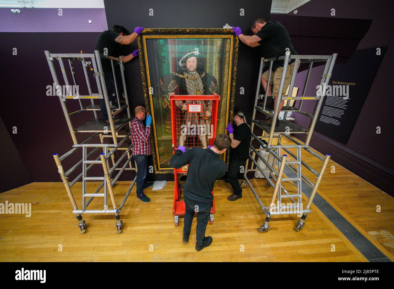 Gallery staff erect a painting of Henry the VIII during a preview of