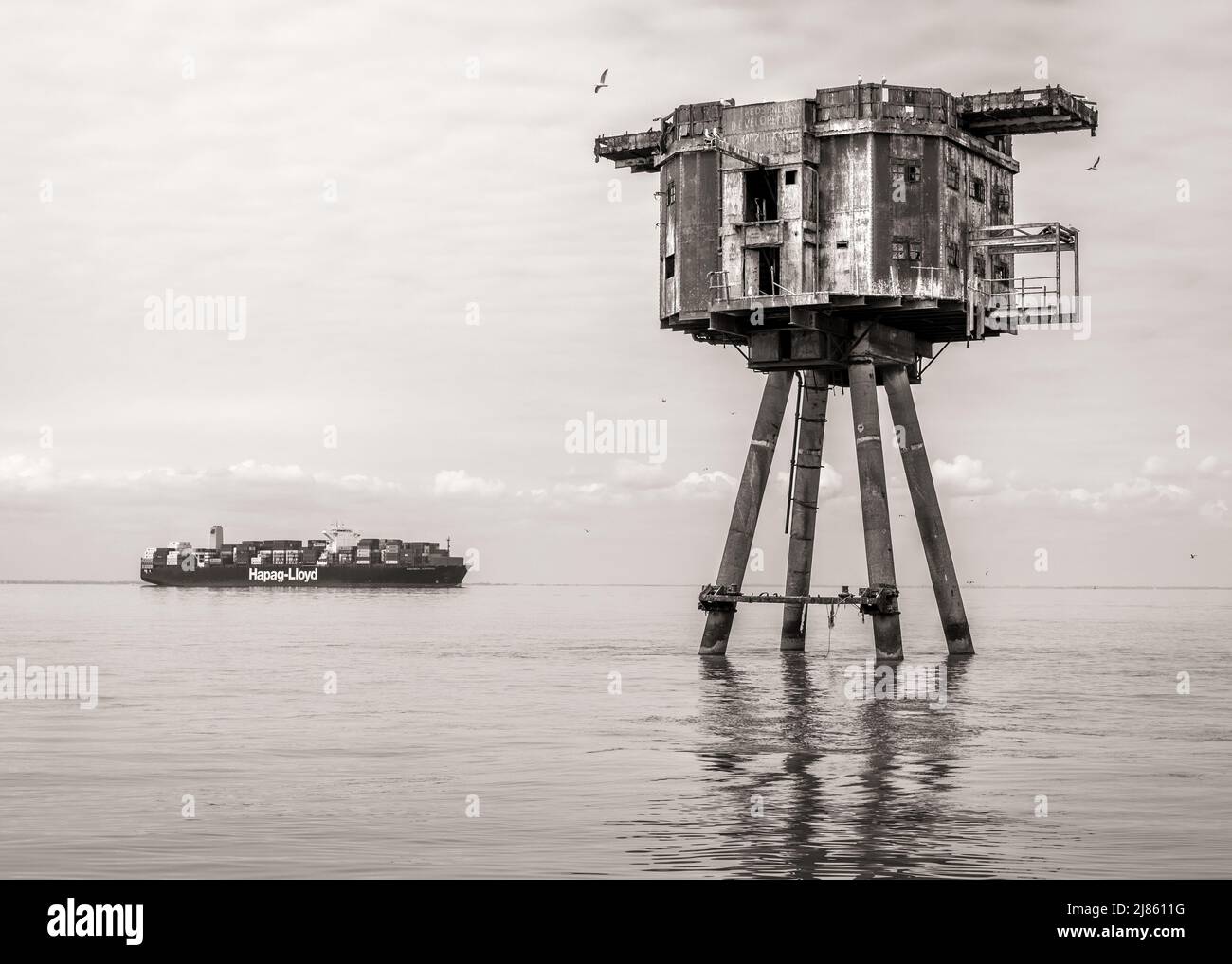 Maunsell Fort and container ship in the Thames Estuary Stock Photo
