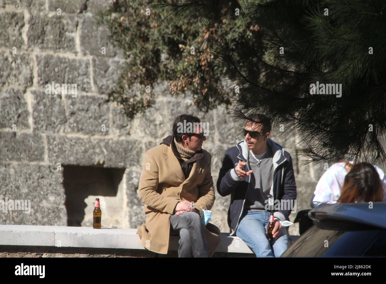 Young men drinking beer on a street in Italy Stock Photo