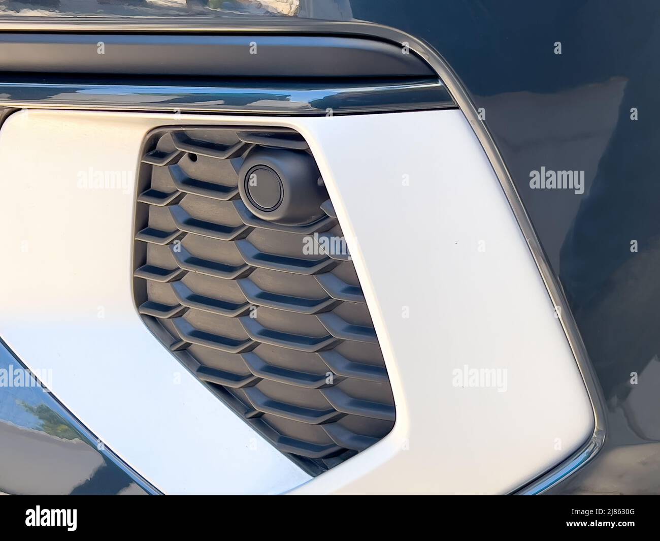 Selective focus parking sensor at front car bumper on light blurred background Stock Photo