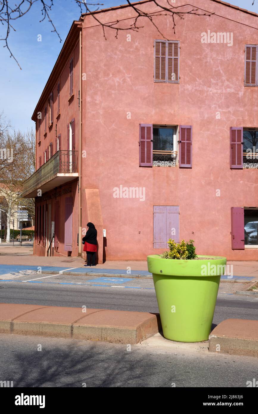 Street Scene with Giant Green Flower Pot or Planter & Brick-Red Building Gardanne Bouches-du-Rhone Provence France Stock Photo