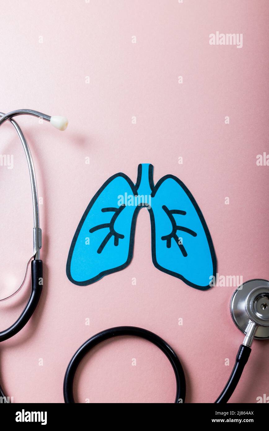 Overhead view of blue paper lungs with stethoscope against pink background, copy space Stock Photo