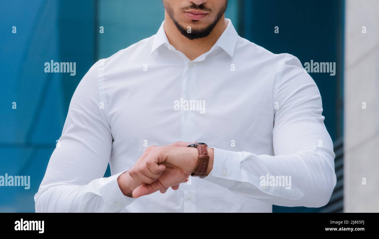 Unrecognizable business man boss leader manager wears white formal shirt looks at wrist watch angry of late time lateness checks hour negative upset Stock Photo