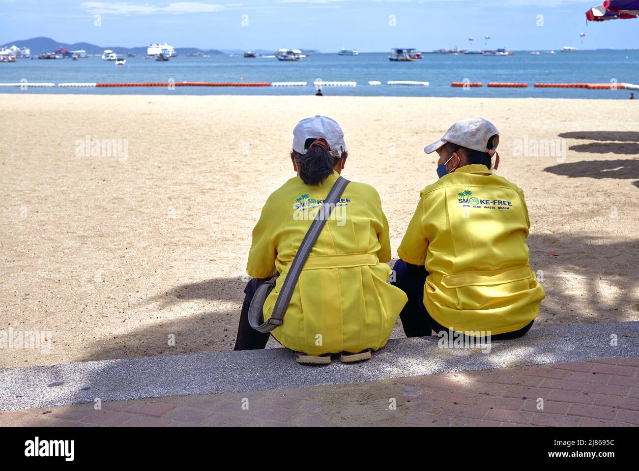 Beach attendants employed to ensure a clean smoke free and waste free beach at Pattaya Thailand Stock Photo