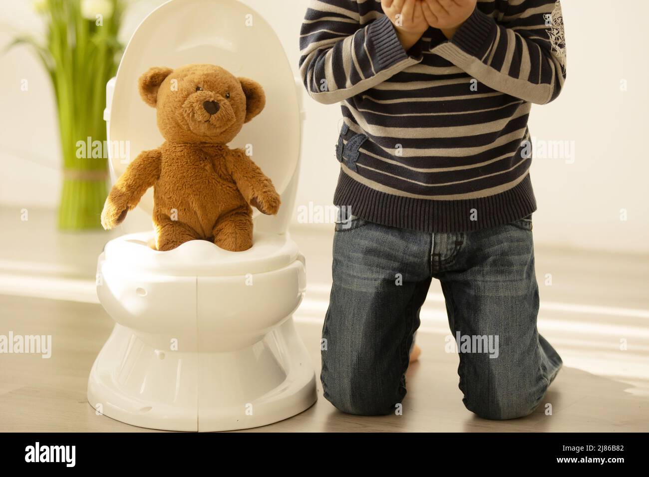 Little toddler child, boy, pee in his pants while playing with toys