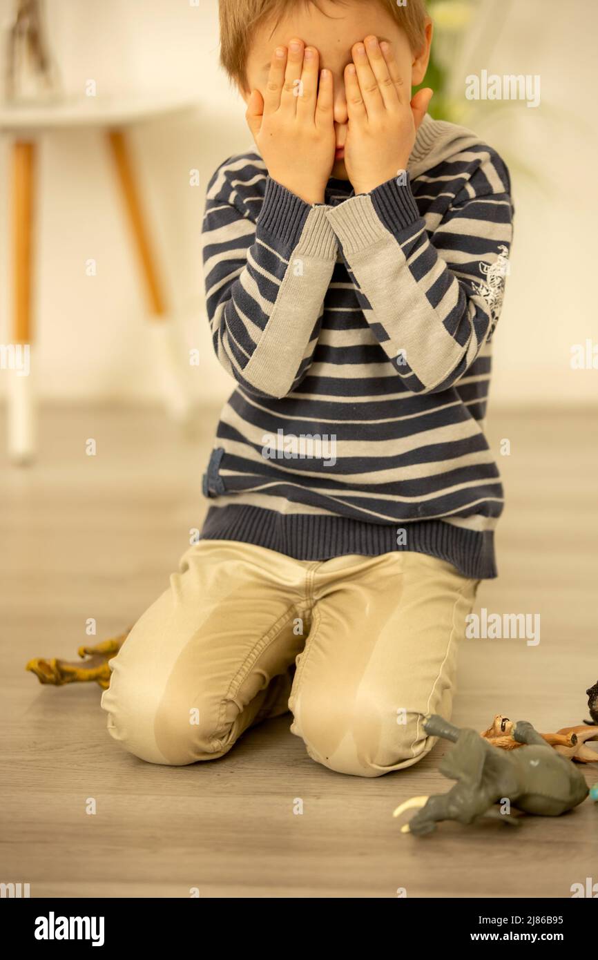 Little toddler child, boy, pee in his pants while playing with toys