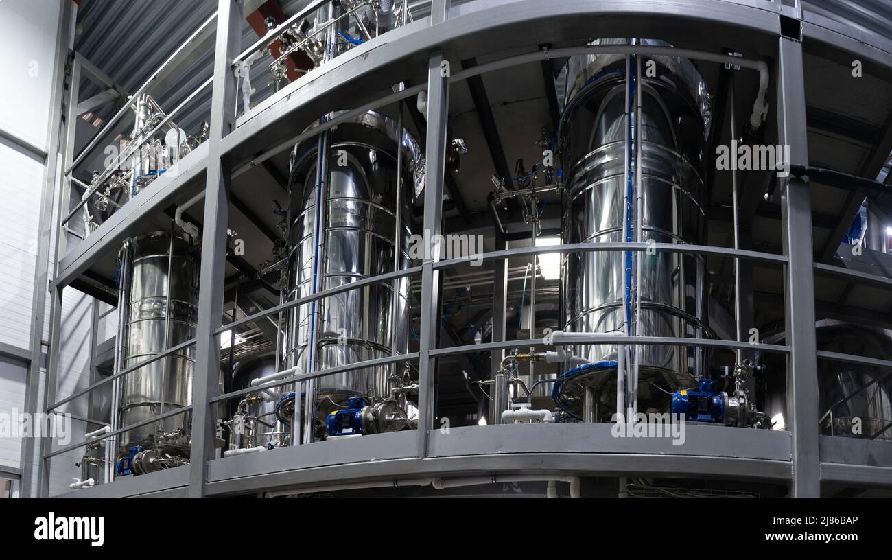 Industrial stainless steel vats. Factory interior, steel pipelines, tubes. Equipment for the