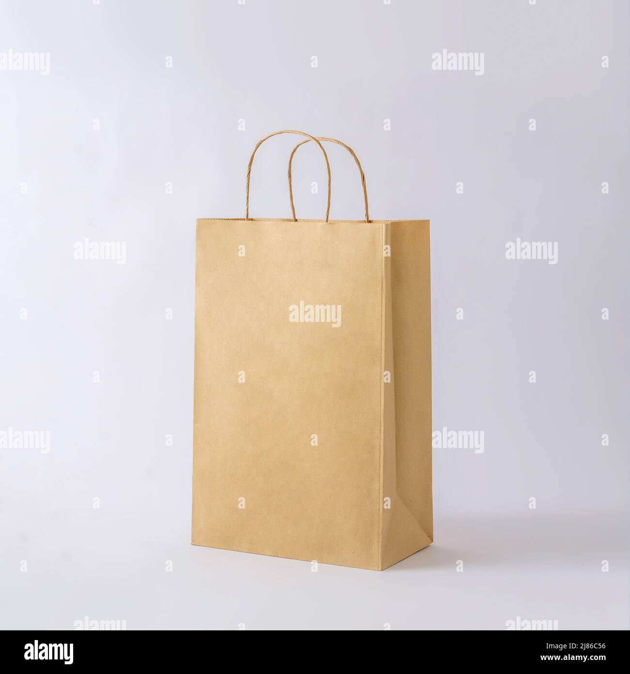 Cardboard brown paper bag for shop shopping and business mockup. Concept of minimal purchase sale and delivery. Stock Photo