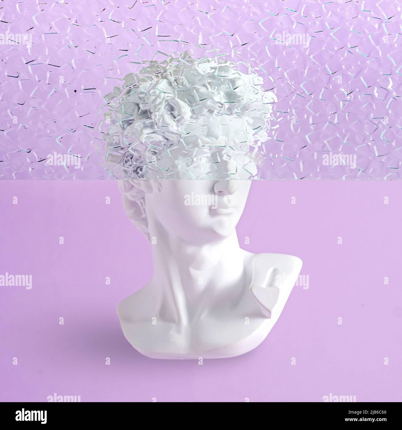 Bust of a statue of David on a purple background with fluted glass and part of the head is hidden. Contemporary minimal vaporwave concept. Stock Photo