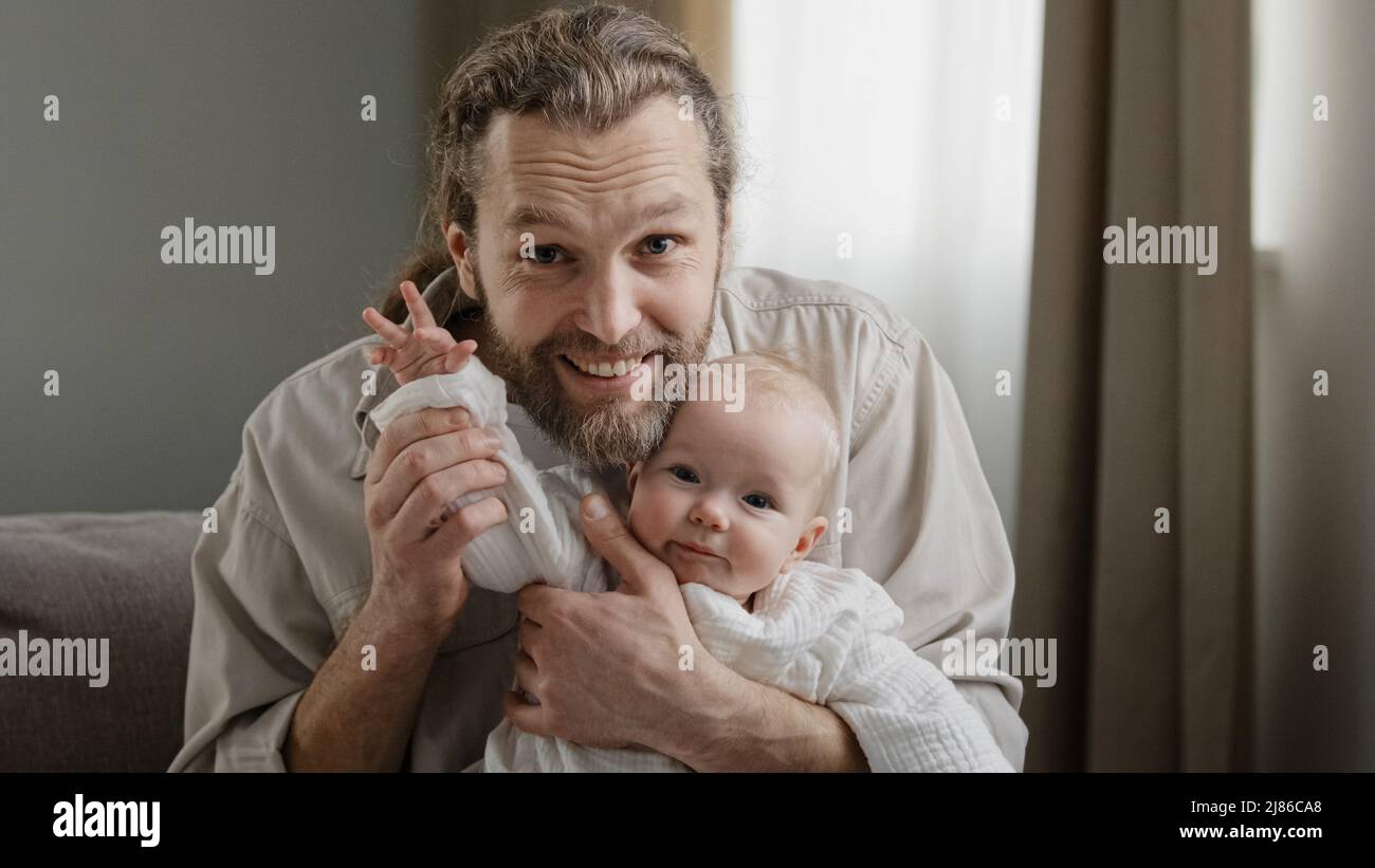 Webcam view portrait caucasian bearded dad and infant newborn small girl little kid daughter son waving hands greeting talking to camera video call at Stock Photo