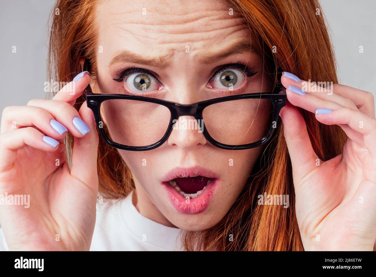 annoying redhaired ginger woman feeling irritation and anger studio background Stock Photo