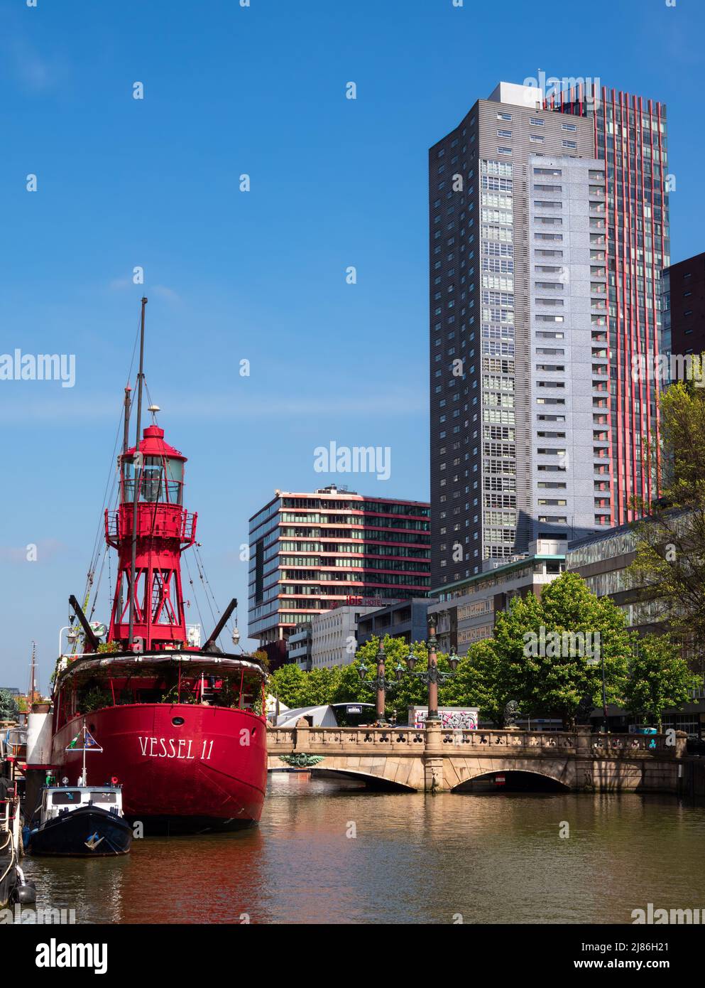 Rotterdam, Netherlands - April 28, 2022: Red ship Vesel II in Rotterdam, converted into a restaurant and modern residential buildings Stock Photo