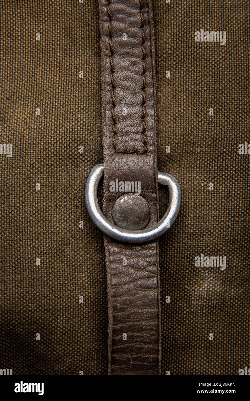 Closeup texture of a canvas fabric backpack. Leather straps and metal
