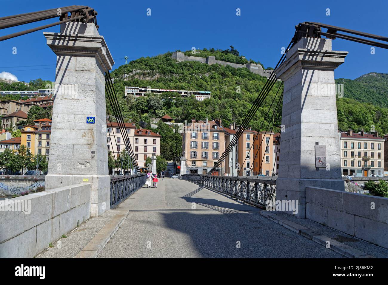 GRENOBLE, FRANCE, May 9, 2022 : Pedestrian Saint-Laurent bridge crosses the Isere river from the city center to the old Saint-Laurent district. Stock Photo