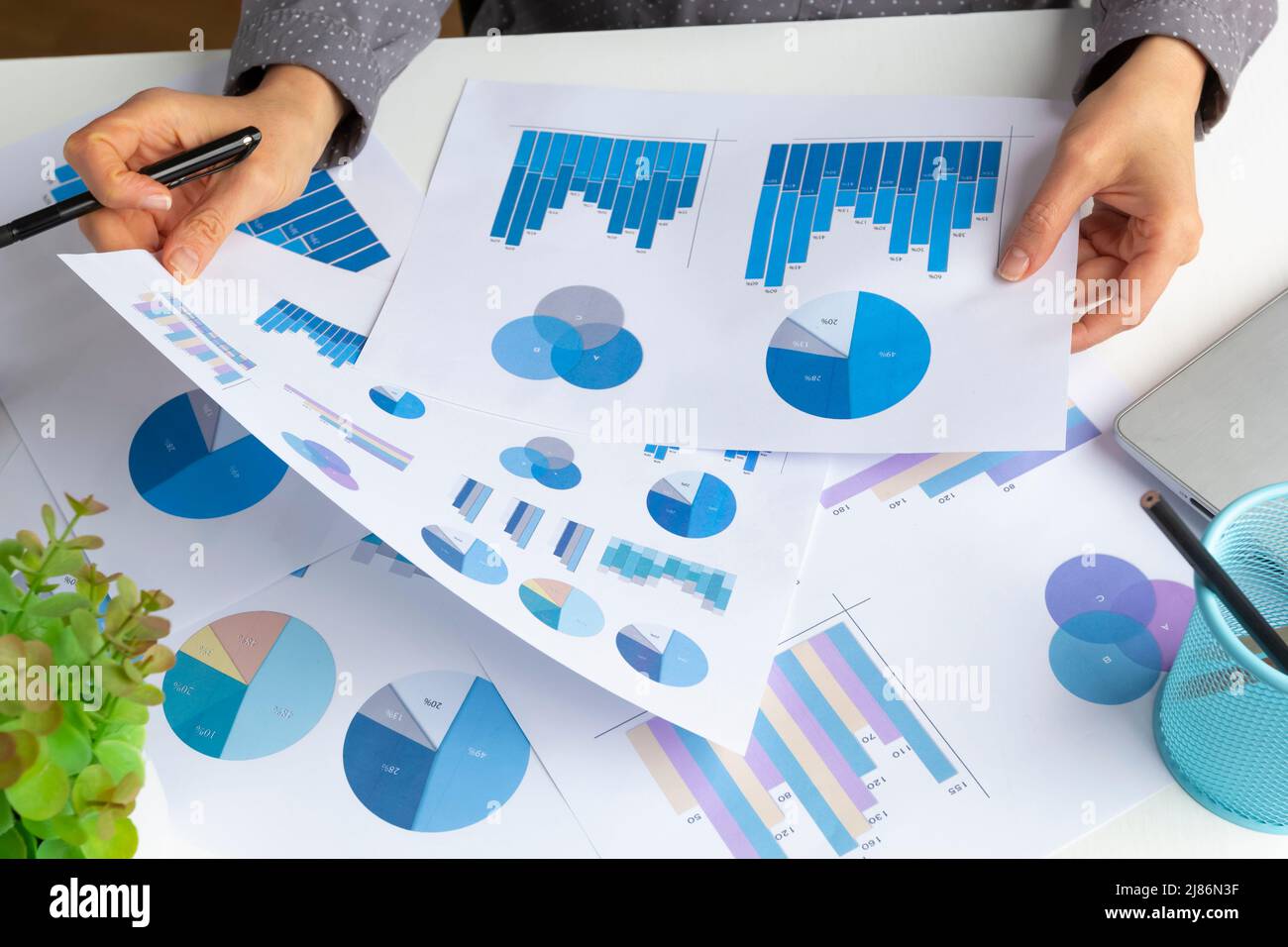 Financial reports, charts and statistics in the hands of an analytics manager. Stock Photo