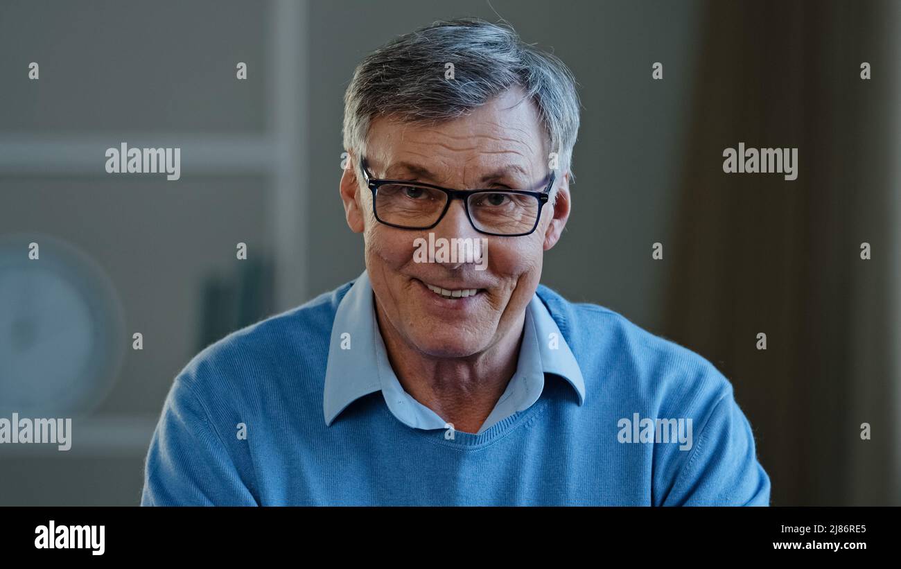 Web cam view mature man sitting at office desk looking at the camera  talking online senior old 60s male teacher in glasses video meeting class  lesson Stock Photo - Alamy