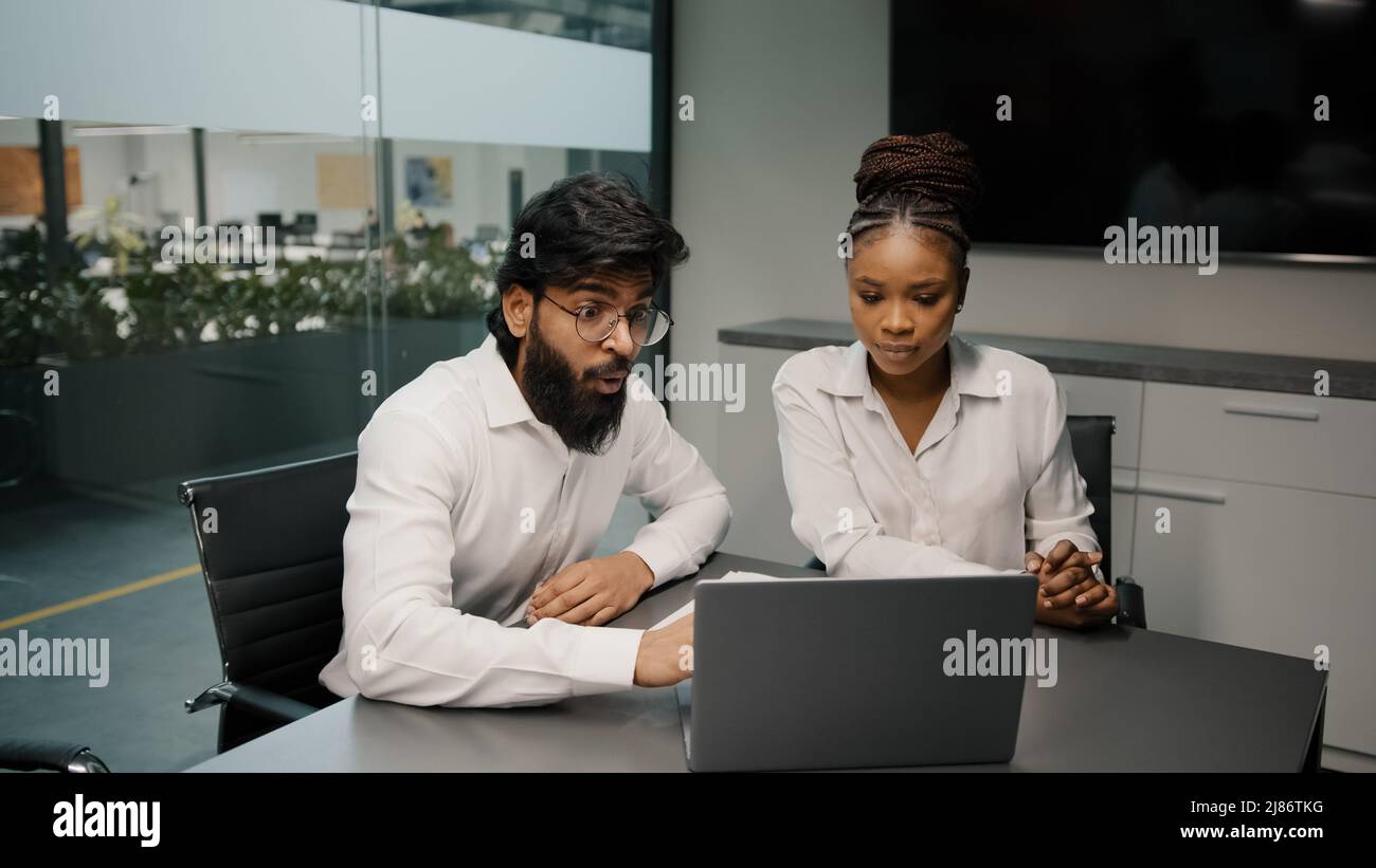 Multiethnic business team diverse people brainstorm in office two arabian men and african woman using laptop computer discussing startup coworkers Stock Photo