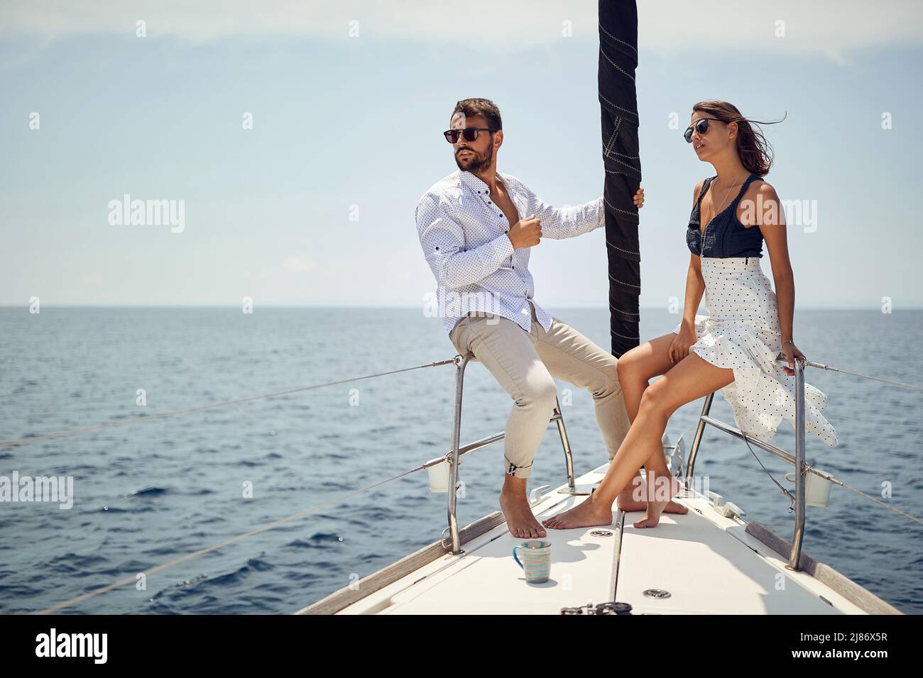 Classy rich couple sailing together on the yacht; Luxurious lifestyle concept Stock Photo