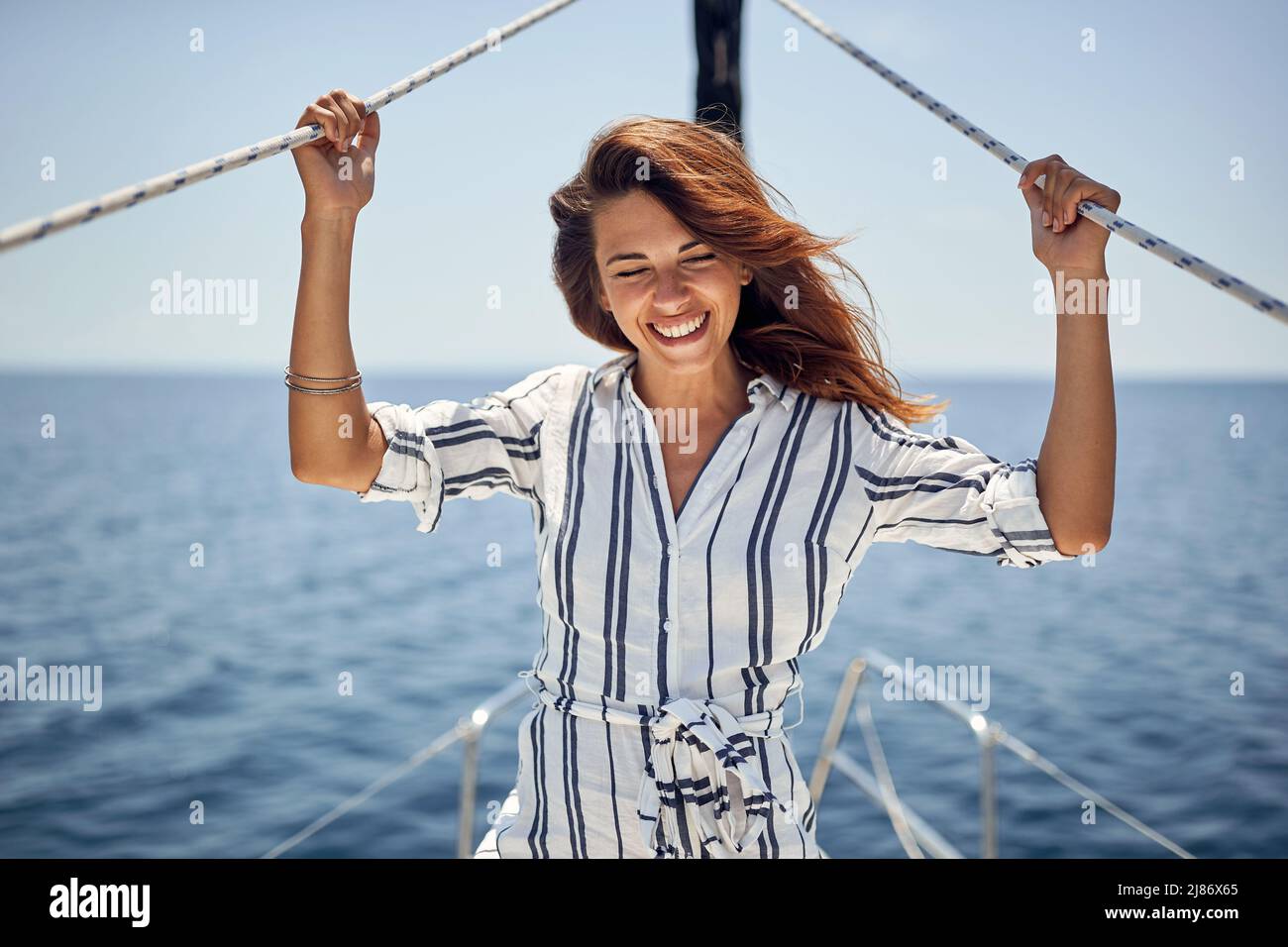 A young handsome female model is enjoying a ride on a yacht on a beautiful sunny day on the sea. Summer, sea, vacation Stock Photo