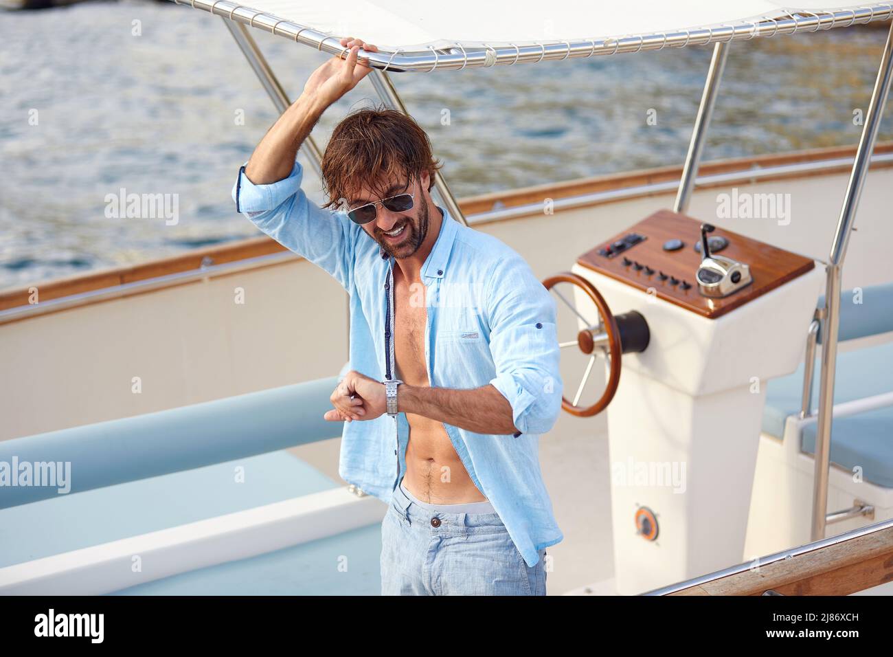summer time. Handsome young man on his sailing boat Stock Photo
