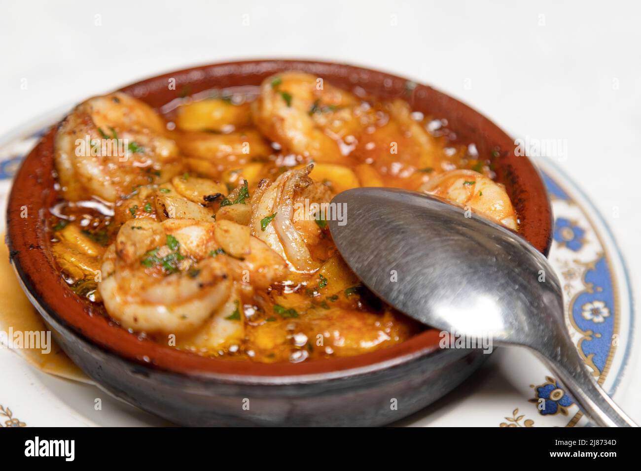 Shrimp cooked in olive oil with garlic (gambas al ajillo) served as an appetiser at a restaurant in Tenerife, Spain. The dish is a popular and traditi Stock Photo