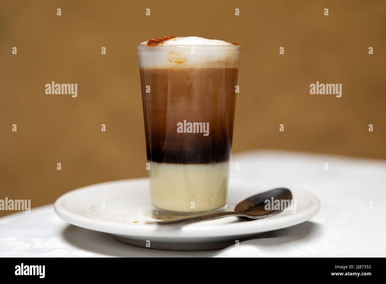 A traditional Barraquito coffee served in Tenerife, Spain. The style of coffee is popular across the Canary Islands and features espresso, frothed mil Stock Photo