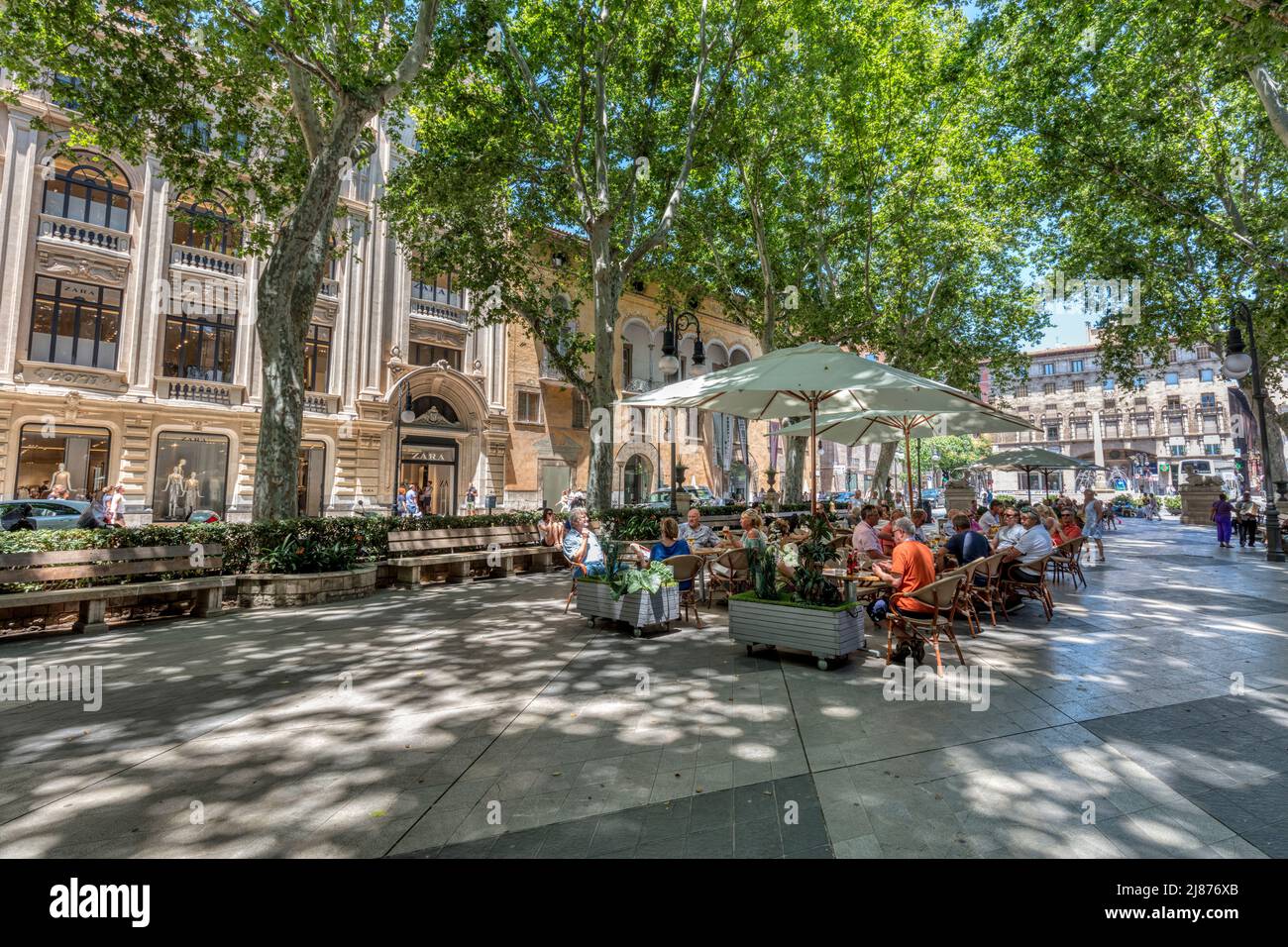 People in the tree lined Passeig del Born a 17th century avenue with high end shopping, cafes and restaurants in old town Palma, Mallorca Stock Photo