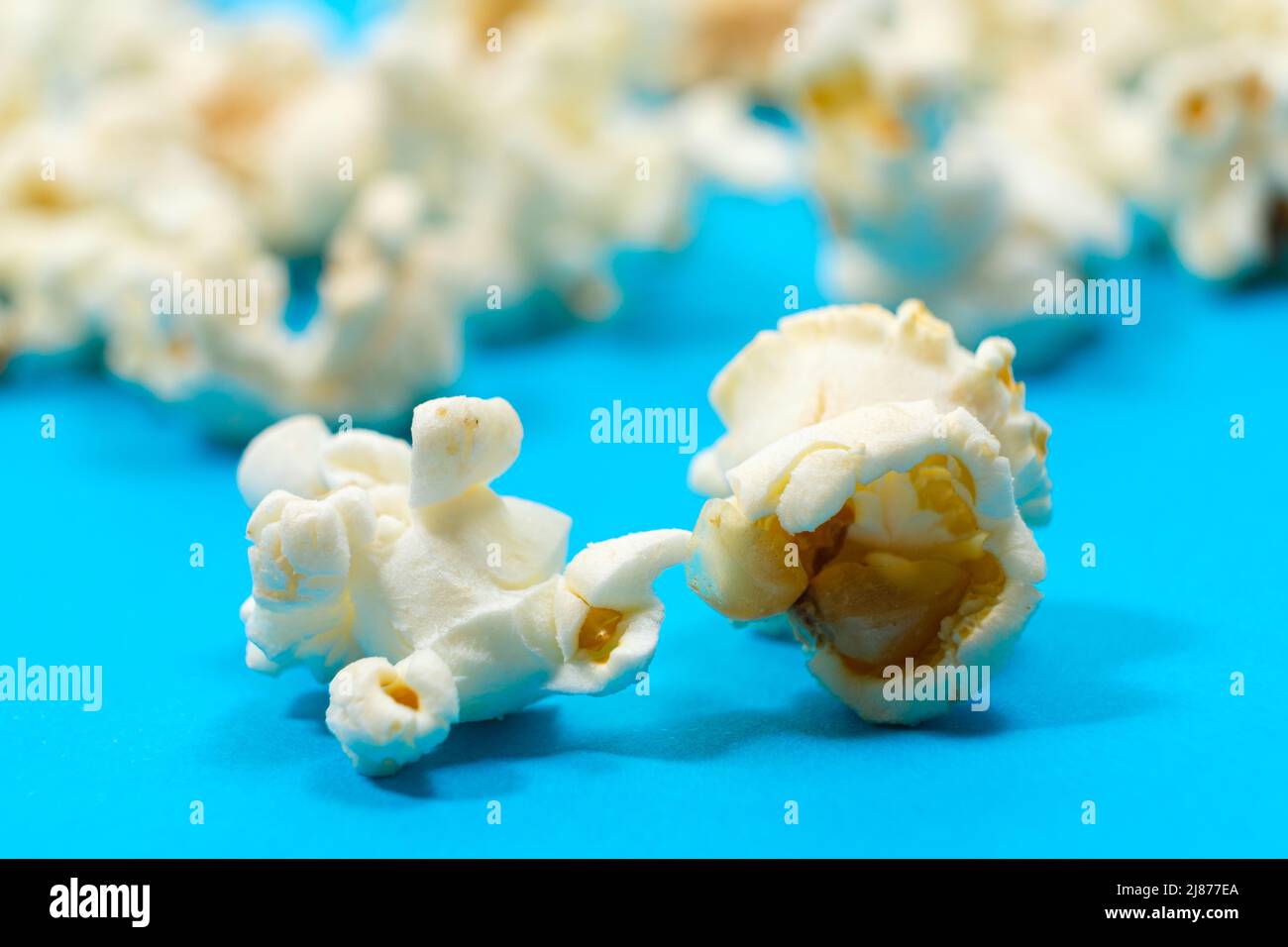 Macro photo of popcorn, corn kernels on a blue background Stock Photo