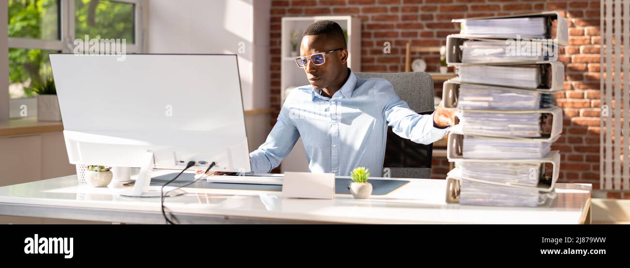 Businessperson Pushing Paper Documents Away And Working With Digital Documents On Computer Instead Stock Photo
