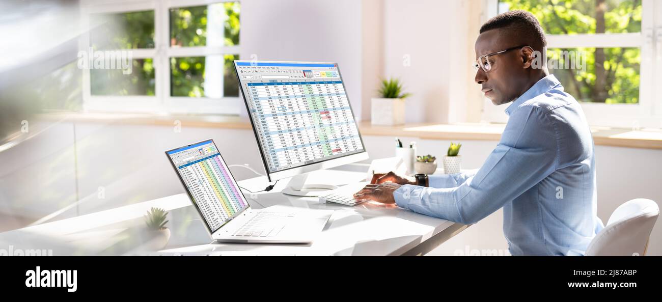 Side View Of Businessman's Hand Analyzing Data On Computer Over Desk Stock Photo