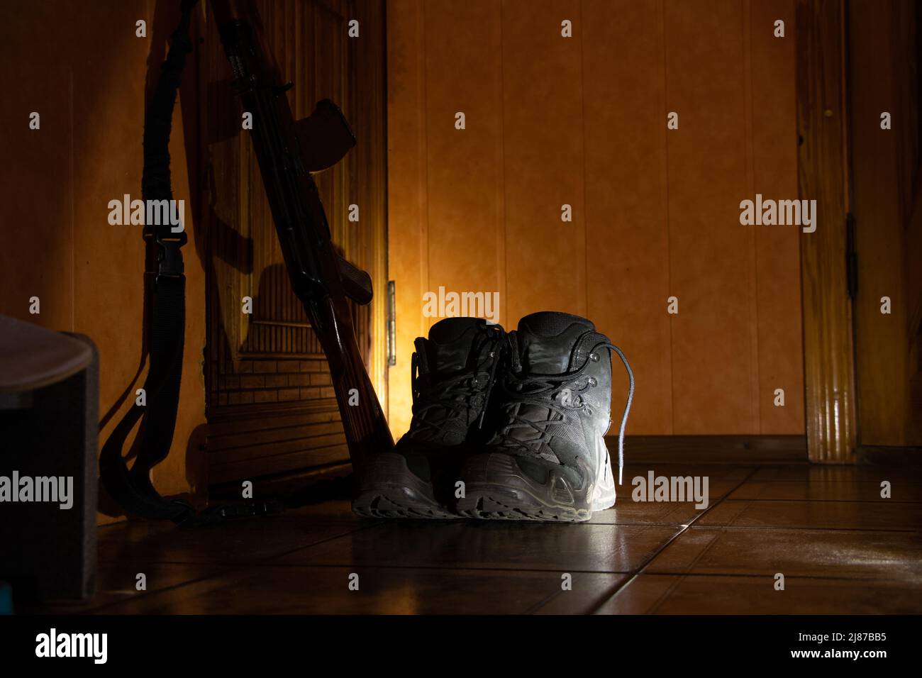 Soldier's boots on the thresholds of the house and a military machine stand nearby, the military returned home in Ukraine, the war 2022 Stock Photo