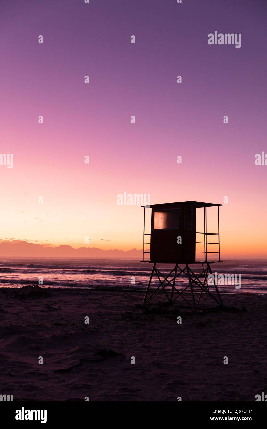 View of silhouette lifeguard hut at sandy beach against scenic view of sea and clear sky, copy space Stock Photo