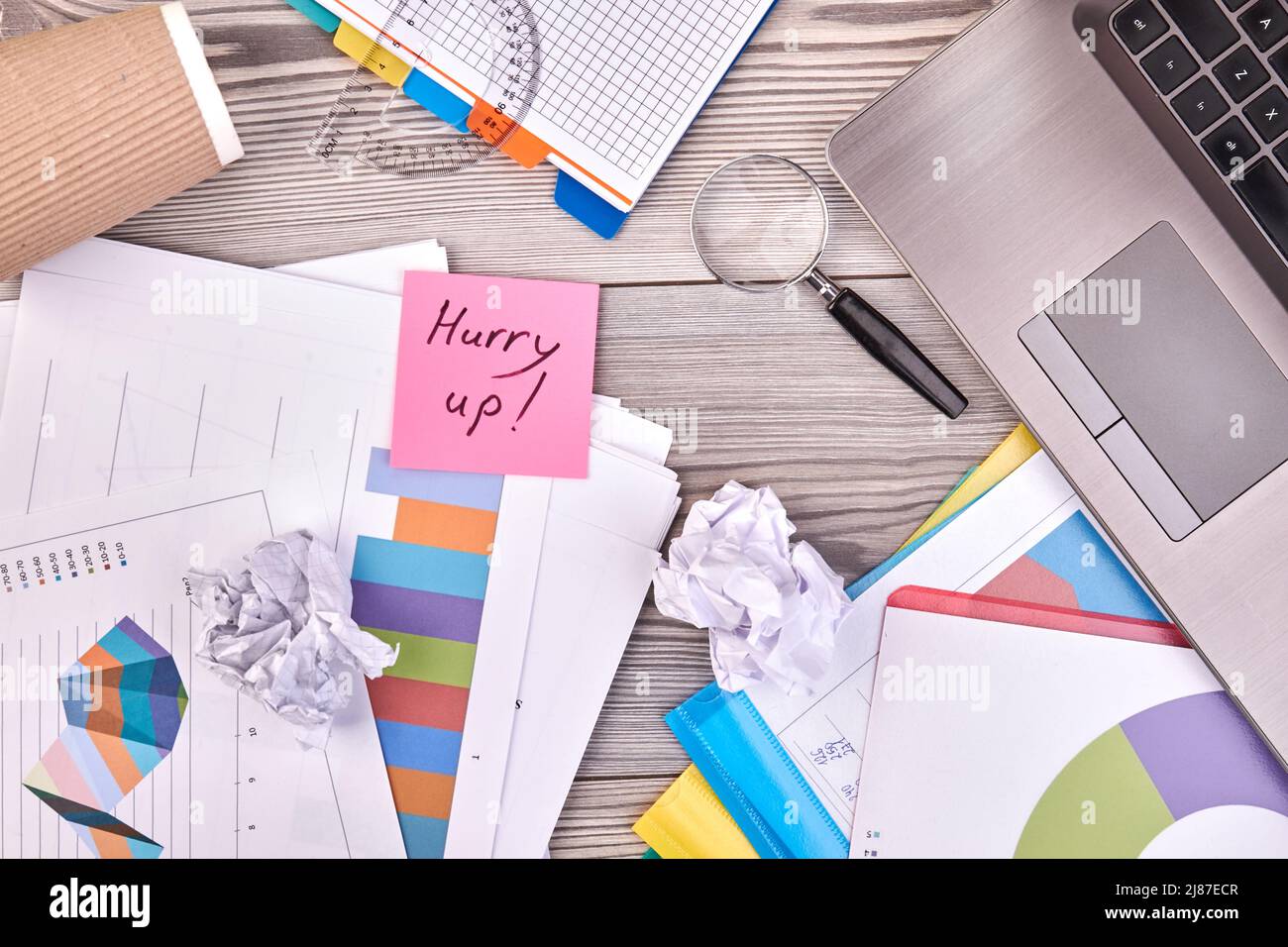 Sticky note with hurry up handwriting and office accessories. White