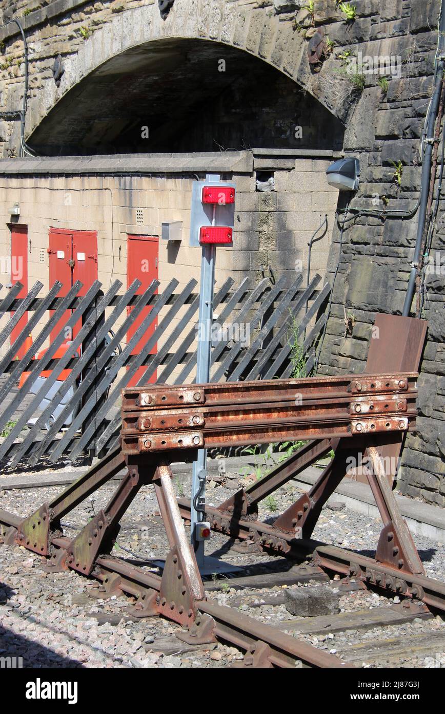Old railway buffer stop at the end of a line at Bradford Interchange railway station with wooden sleepers in the track. Stock Photo