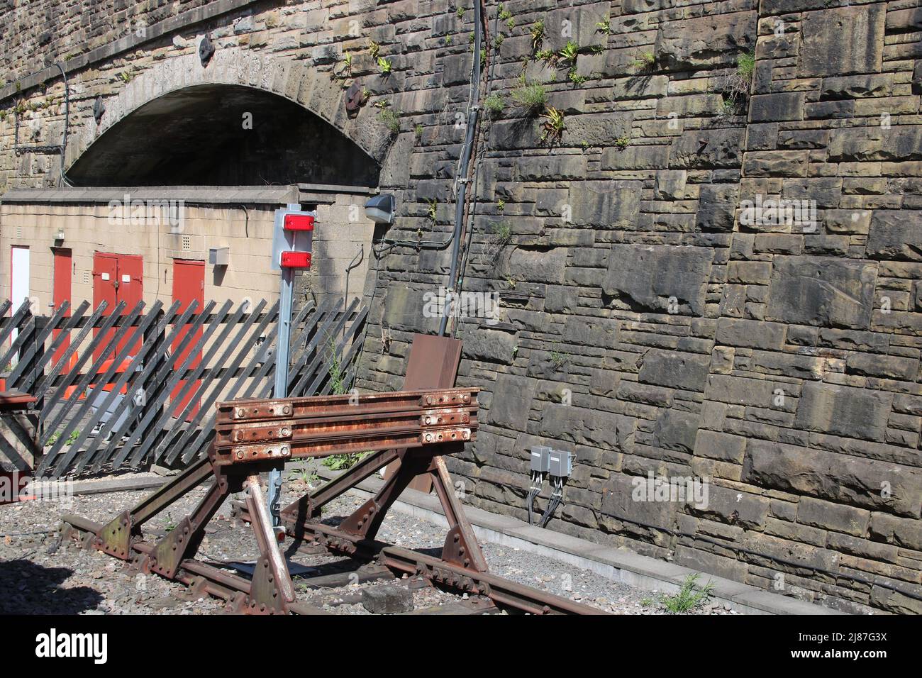 Old railway buffer stop at the end of a line at Bradford Interchange railway station with wooden sleepers in the track. Stock Photo