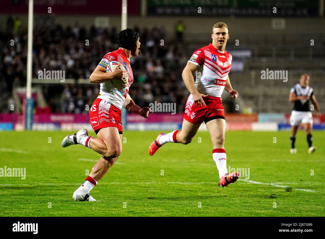 St Helens' Jonny Lomax (second) on their way to scoring his side's third try of the game during the Betfred Super League match at the Totally Wicked Stadium, St Helens. Picture date: Friday May 13, 2022. Stock Photo