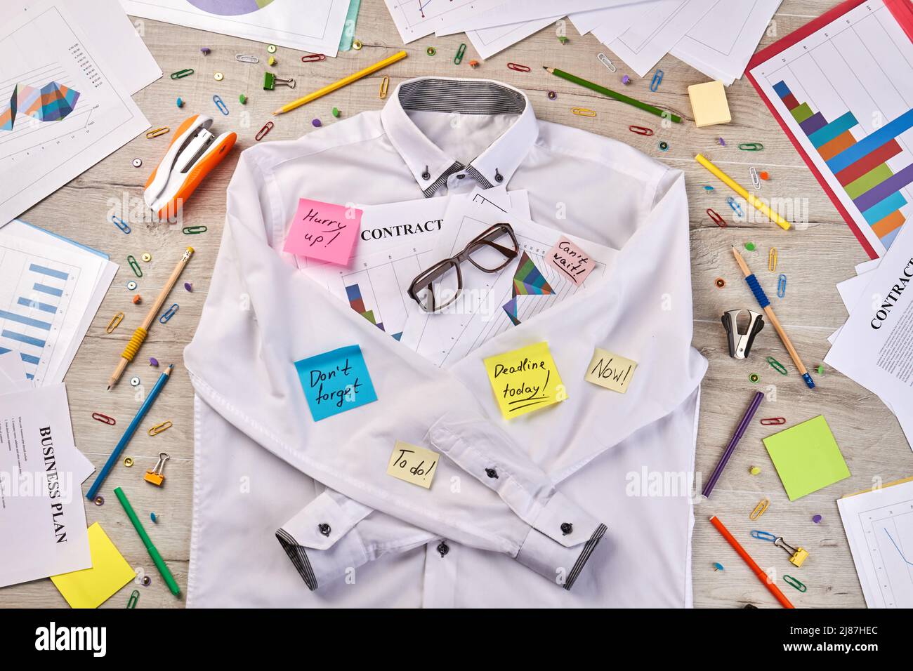 Top view flat lay white shirt and office stationery stuff. Paperclips with stapler and pens. Stock Photo