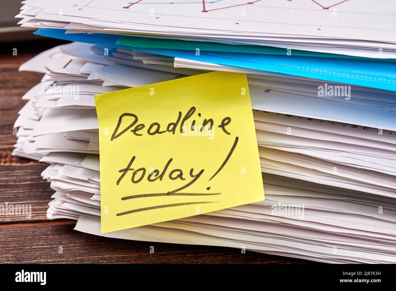 Sticky note with deadline today writing on the stack of papers. Files ...